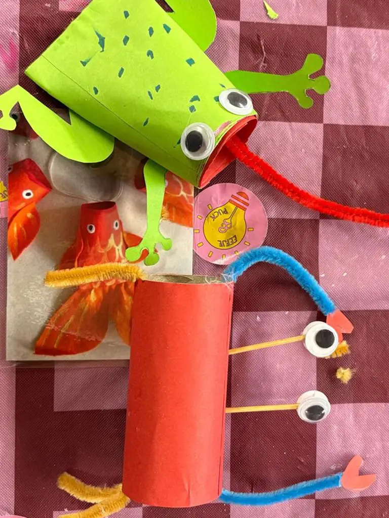 Een groene kikker, oranje visjes en figuurtjes met wiebelogen, gemaakt van wc-rollen en pijpenragers.