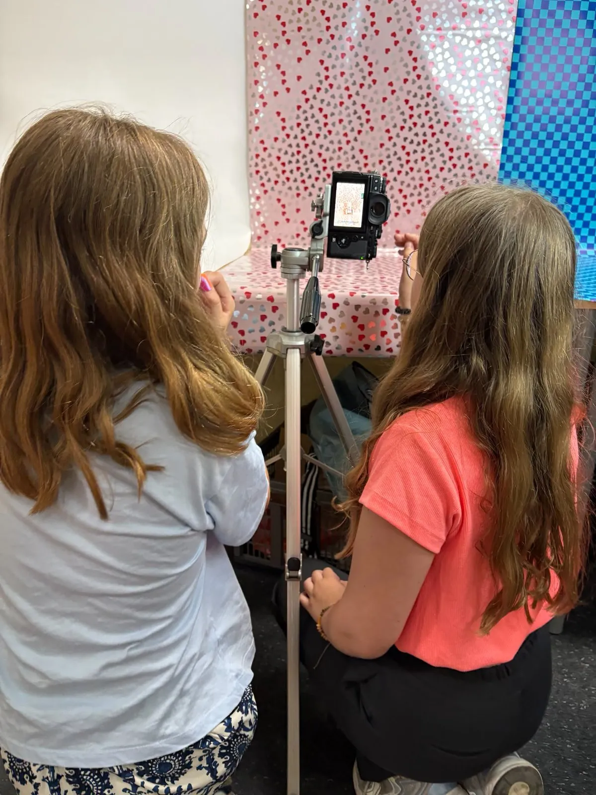 Twee leerlingen fotograferen hun robot met een camera op statief